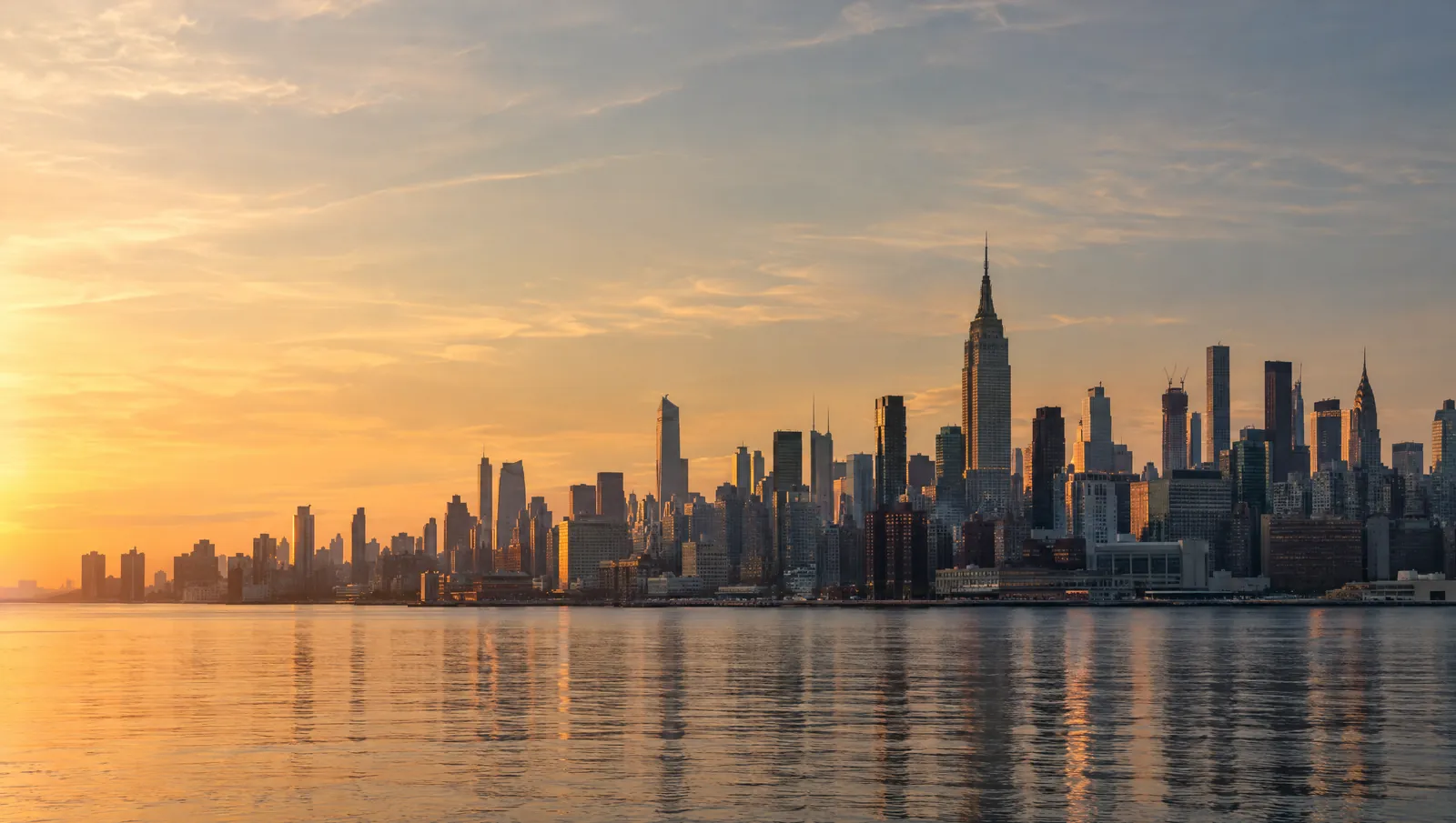 Manhattan skyline at golden hour across the river